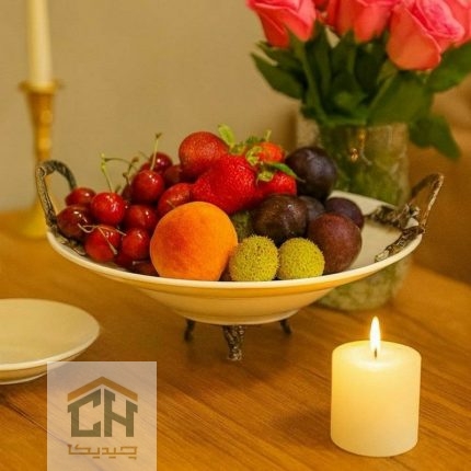 میوه خوری گرد دسته پیوتر با چیدمان میوه های رنگارنگ