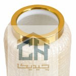 نمای نزدیک حلقه طلایی و بافت برجسته شیشه کرم