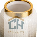 نمای نزدیک نوار طلایی و بافت شیشه ای سفید در بالای گلدان